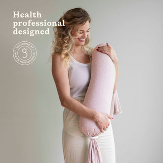 Woman holding a pink bbhugme nusing pillow with 