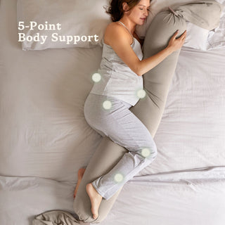 Woman using a bbhugme pregnancy pillow on a bed with text 